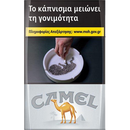 A Camel cigarette pack design with a prominent health warning banner in Greek at the top, showing a hand placing tobacco into an ashtray. The lower section features the gray 'CAMEL' logo and a yellow camel illustration on a white striped background.