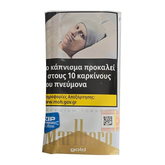 A pack of Marlboro Gold premium tobacco cigarettes with a prominent Greek health warning label on the front, featuring a portrait of a person smoking and health text.