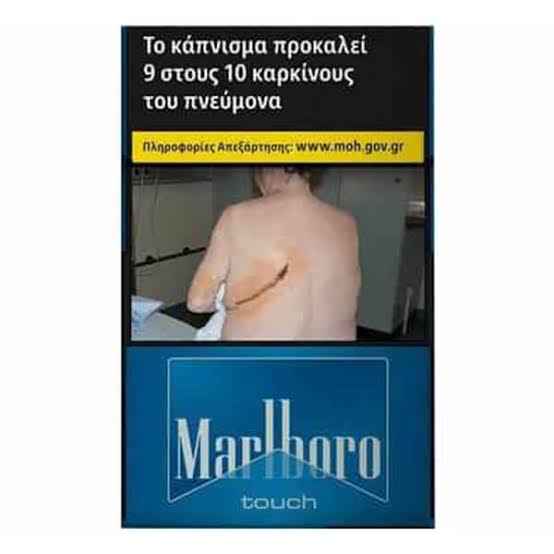 Marlboro Touch cigarette pack featuring a health warning in Greek with a photo of a back with a scar, above a blue Marlboro Touch logo.